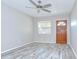 Bright and airy living room featuring stylish wood-look floors, a ceiling fan, and a front entry door at 6004 S 82Nd St, Tampa, FL 33619