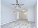 Open-concept living room with modern flooring, neutral walls, a ceiling fan, and access to the backyard at 6004 S 82Nd St, Tampa, FL 33619