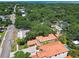 An aerial view shows a beautiful home with lush greenery, a terracotta roof, brick driveway and backyard swimming pool at 6008 Interbay Blvd, Tampa, FL 33611