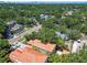 A neighborhood aerial showcases lush greenery, mature trees, terracotta roofs and a view of the city skyline at 6008 Interbay Blvd, Tampa, FL 33611