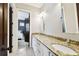 Bathroom featuring granite counters, double sinks, white cabinets, and modern lighting at 6008 Interbay Blvd, Tampa, FL 33611