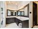 Bathroom featuring double sinks with granite counters, wood cabinetry, and ornate mirrors and lighting at 6008 Interbay Blvd, Tampa, FL 33611