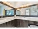 Bathroom with dual sinks, granite countertops, dark wood cabinets, stylish lighting, and ornate framed mirrors at 6008 Interbay Blvd, Tampa, FL 33611