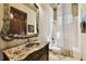 Bathroom featuring an ornate mirror, marble countertop vanity, and a shower with floral curtain at 6008 Interbay Blvd, Tampa, FL 33611