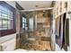 Tiled shower with glass door, window, and neutral earth-toned tile at 6008 Interbay Blvd, Tampa, FL 33611