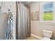 Cozy bathroom with a shower, toilet, and a window with shutters at 6008 Interbay Blvd, Tampa, FL 33611