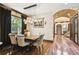 Dining room featuring a wooden table, arched entranceway, wood floors, and pendant lighting at 6008 Interbay Blvd, Tampa, FL 33611