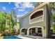 Rear home view showcasing the pool, balcony, outdoor kitchen, lush landscaping at 6008 Interbay Blvd, Tampa, FL 33611