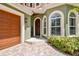 The main entrance features a wooden front door, arched windows, and a brick paved entryway at 6008 Interbay Blvd, Tampa, FL 33611