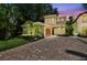 Charming two-story home boasts lush landscaping, a terracotta tile roof, and a brick driveway at 6008 Interbay Blvd, Tampa, FL 33611