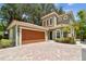 This charming house features a terracotta tile roof, a two-car garage, and a brick driveway at 6008 Interbay Blvd, Tampa, FL 33611
