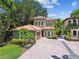 Charming Mediterranean-style home with a lush landscape, tiled roof and a brick driveway at 6008 Interbay Blvd, Tampa, FL 33611