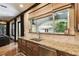 This kitchen features stone counters and stainless steel appliances overlooking lush landscaping at 6008 Interbay Blvd, Tampa, FL 33611