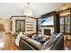 Spacious living room featuring a cozy fireplace, hardwood flooring, and a large sectional sofa at 6008 Interbay Blvd, Tampa, FL 33611