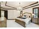 Spacious main bedroom showcases a tufted headboard, detailed trim, and ample natural light from shuttered windows at 6008 Interbay Blvd, Tampa, FL 33611