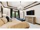 Luxurious main bedroom featuring balcony access, a crystal chandelier, and warm, inviting decor at 6008 Interbay Blvd, Tampa, FL 33611