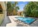 A backyard pool surrounded by travertine tile deck and lush tropical landscaping at 6008 Interbay Blvd, Tampa, FL 33611