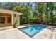 Backyard featuring a pool with travertine tile decking and tropical landscaping at 6008 Interbay Blvd, Tampa, FL 33611