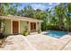 Backyard featuring pool with travertine tile decking and a tropical landscape at 6008 Interbay Blvd, Tampa, FL 33611