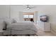 Bright bedroom with a ceiling fan, light tiled floor, balcony access and a modern dresser at 6265 Sun Blvd # 1203, St Petersburg, FL 33715