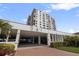 A multi-story condo building featuring a covered parking area and beautiful landscaping at 6265 Sun Blvd # 1203, St Petersburg, FL 33715