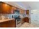 Well-lit kitchen with stainless steel appliances, wooden cabinets, granite countertops and tile floors at 6265 Sun Blvd # 1203, St Petersburg, FL 33715