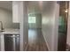 Hallway view towards a room with a window, stainless steel dishwasher and sink visible to the left at 6520 Thicket Trl, New Port Richey, FL 34653