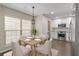 Cozy dining area with a wood table, white chairs, a large window, and a view into the modern kitchen at 6826 Rosemary Dr, Tampa, FL 33625