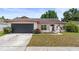 Inviting single-story home with a well-maintained lawn, lovely landscaping, and a two-car garage at 6826 Rosemary Dr, Tampa, FL 33625