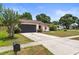 Attractive single-story home featuring a dark garage door and lovely front garden at 6826 Rosemary Dr, Tampa, FL 33625