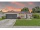 Charming single-story home showcasing a well-manicured lawn and an attached garage under a beautiful sky at 6826 Rosemary Dr, Tampa, FL 33625