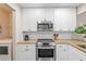 Kitchen with stainless steel appliances, white cabinets, granite countertops, with laundry room access for added convenience at 6826 Rosemary Dr, Tampa, FL 33625