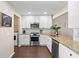 Bright, renovated kitchen with white cabinets, stainless steel appliances, and modern countertops, adjacent to laundry area at 6826 Rosemary Dr, Tampa, FL 33625