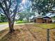 View of the house including front yard, driveway, landscaping, and mature trees at 7001 86Th N Ave, Pinellas Park, FL 33782