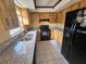 A functional kitchen features granite countertops and black appliances at 7001 86Th N Ave, Pinellas Park, FL 33782