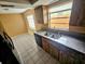 This charming kitchen includes dark wooden cabinetry and a granite countertop at 7001 86Th N Ave, Pinellas Park, FL 33782