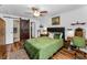 Cozy bedroom with hardwood floors, barn door to bathroom, and comfortable green bedding at 704 Lyndhurst St # 624, Dunedin, FL 34698