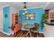 Colorful dining area featuring turquoise walls, painted cabinet, round wood table, and hanging lights at 704 Lyndhurst St # 624, Dunedin, FL 34698