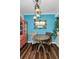 Cozy dining area with blue walls, decorative mirror and colorful hanging lights above wood table at 704 Lyndhurst St # 624, Dunedin, FL 34698