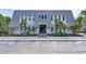Attractive three-story condo building featuring a unique roof design and tropical landscaping at 704 Lyndhurst St # 624, Dunedin, FL 34698