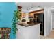 Galley kitchen features a breakfast bar, black appliances, granite counters and modern track lighting at 704 Lyndhurst St # 624, Dunedin, FL 34698
