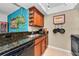 Kitchen with wood cabinets, granite countertops, tile floors and stainless dishwasher and sink at 704 Lyndhurst St # 624, Dunedin, FL 34698