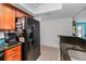 Kitchen featuring granite counters, tile floors, black appliances, and access to dining area at 704 Lyndhurst St # 624, Dunedin, FL 34698