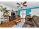 Cozy living room featuring a ceiling fan, wood floors, and an entertainment center at 704 Lyndhurst St # 624, Dunedin, FL 34698