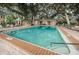 Scenic community pool with turquoise water and a sun-drenched pool deck with mature landscaping at 704 Lyndhurst St # 624, Dunedin, FL 34698