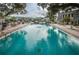 Beautiful community pool surrounded by lush landscaping and comfortable seating at 704 Lyndhurst St # 624, Dunedin, FL 34698