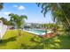 Large, grassy backyard with outdoor furniture, swimming pool, landscaping, and fenced perimeter at 743 43Rd Ne Ave, St Petersburg, FL 33703
