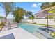 Backyard features a luxurious pool surrounded by a white fence and tropical landscaping at 743 43Rd Ne Ave, St Petersburg, FL 33703