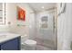 Stylish bathroom featuring a shower with glass doors and gold hardware, a modern toilet, and a blue vanity at 743 43Rd Ne Ave, St Petersburg, FL 33703
