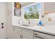 Bright kitchen featuring a stainless steel sink, white cabinets, marble countertops, and a window view to the outside at 743 43Rd Ne Ave, St Petersburg, FL 33703